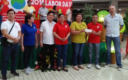 <p><strong>LABOR ASSISTANCE.</strong> Department of Labor and Employment Western Visayas Regional Director Johnson Canete (second from right) awards the PHP400,000 livelihood check for the Negosyo sa Kariton Project of 20 selected beneficiaries from Barangays Sto. Rosario, Buenavista in Guimaras on Tuesday (May 1, 2018).  <em>(Photo by Perla Lena) </em></p>